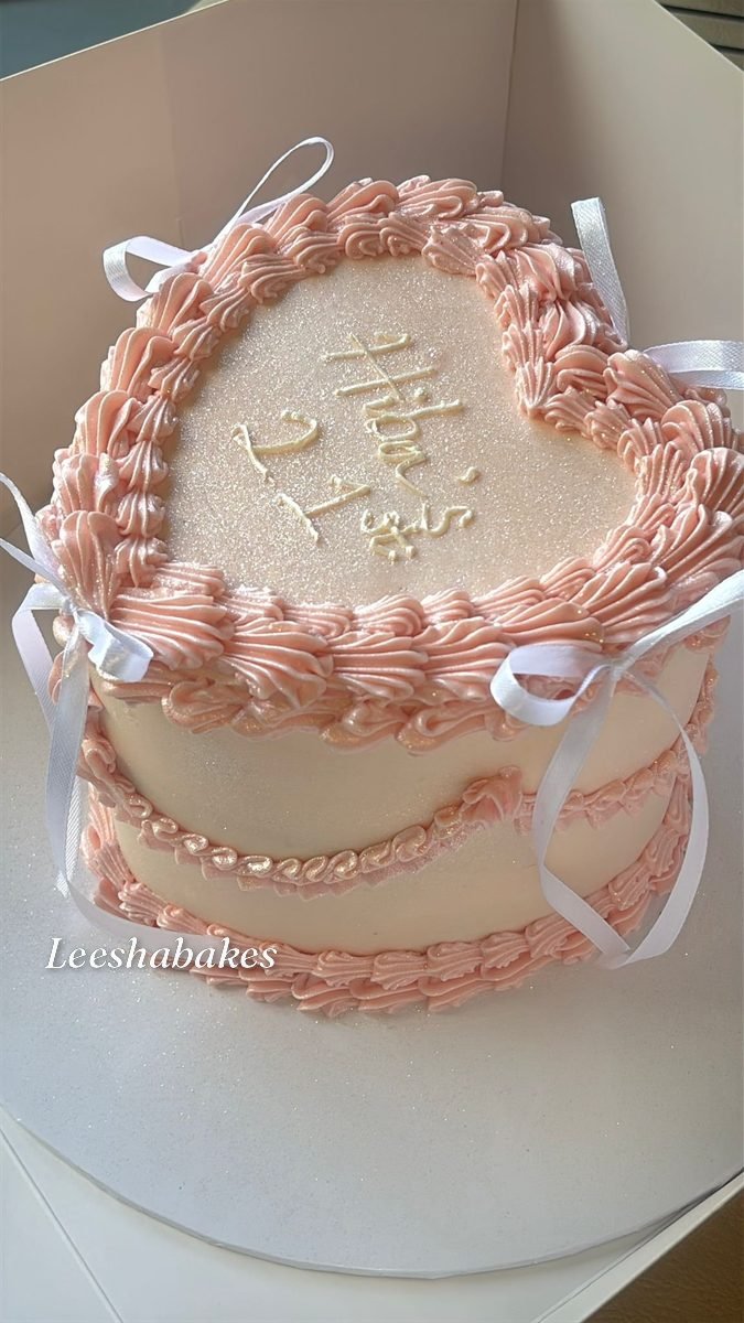Pink heart cake with white ribbon bows