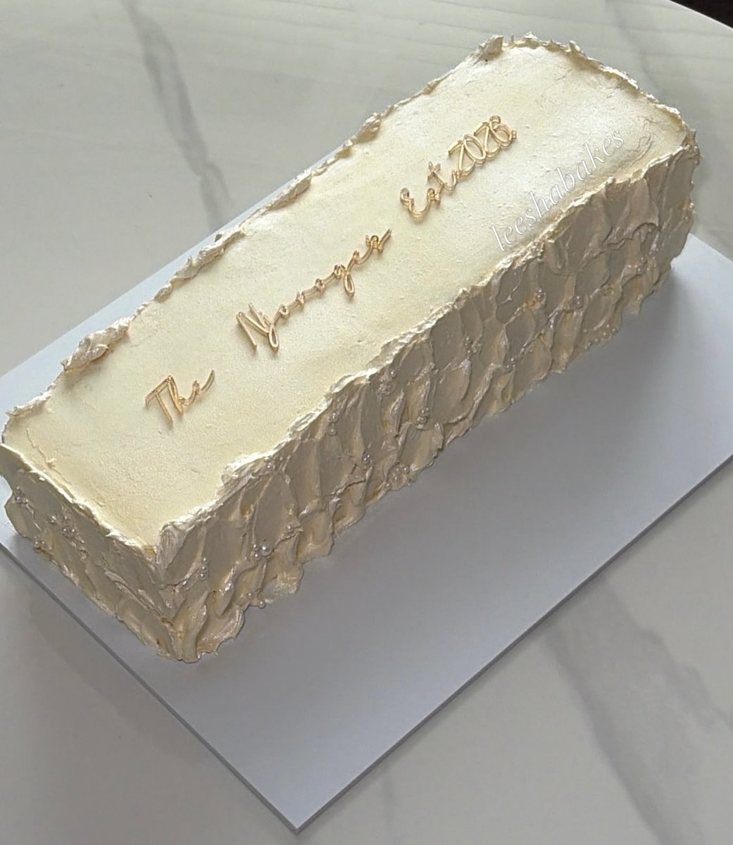 Ivory buttercream loaf cake with a textured palette-knife finish and gold script reading 'The Morgans est 2026'