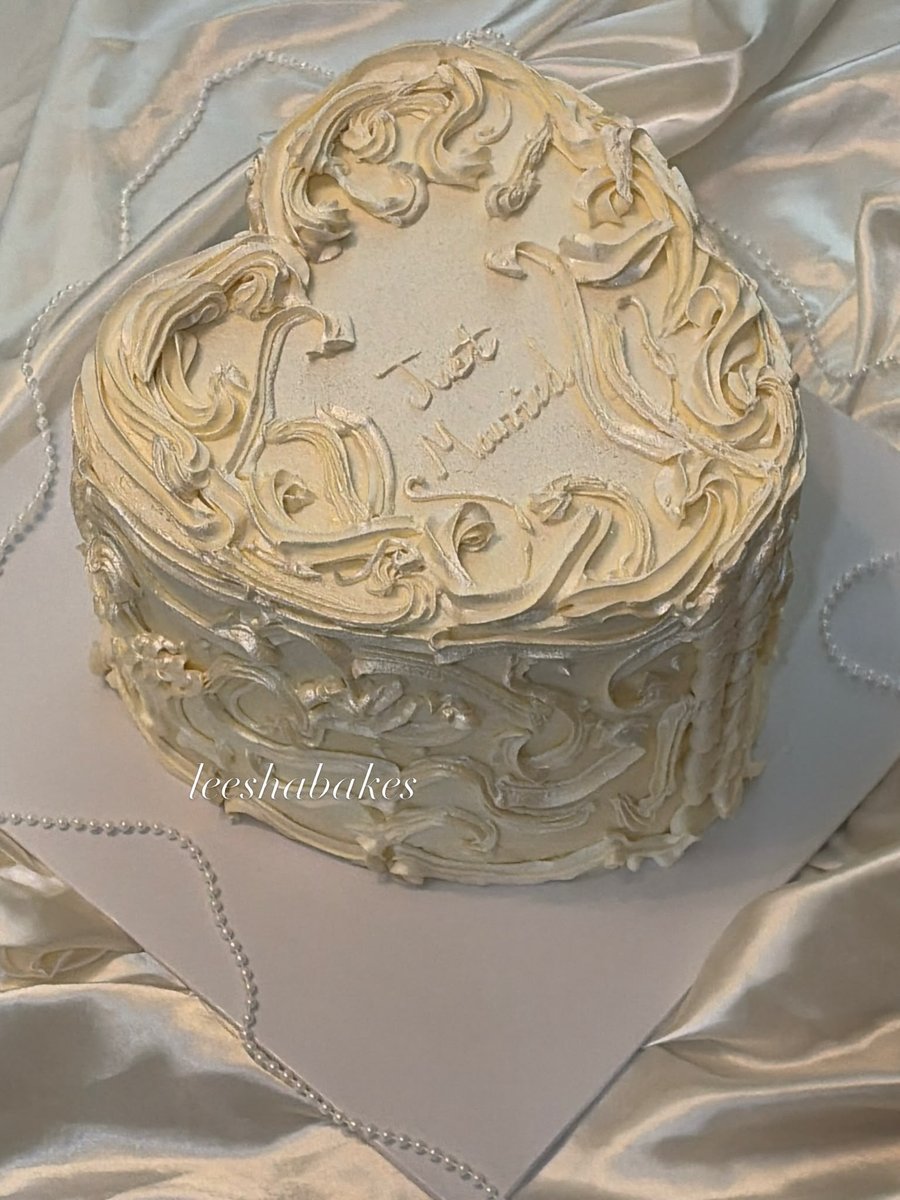 Cream heart cake with baroque piping reading 'Just Married'