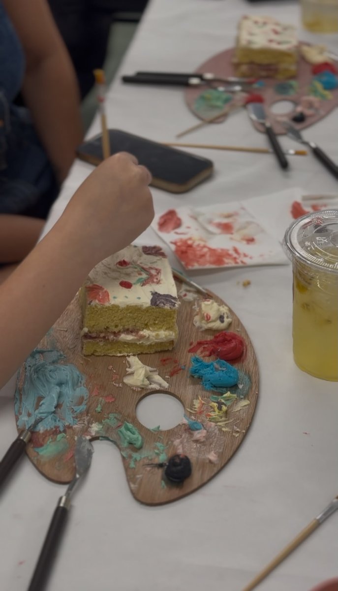 Decorating a painted cake with palette knives at the cake painting event